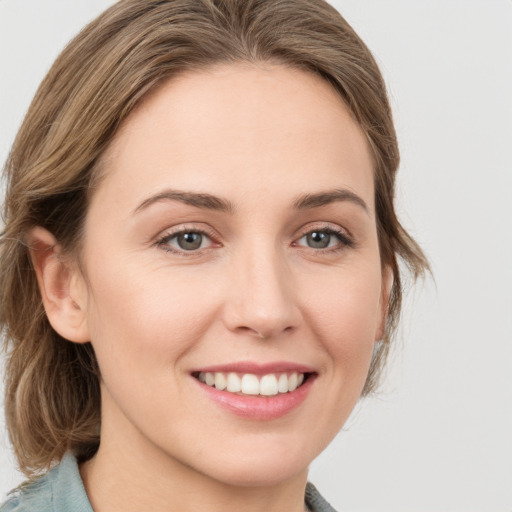 Joyful white young-adult female with medium  brown hair and green eyes