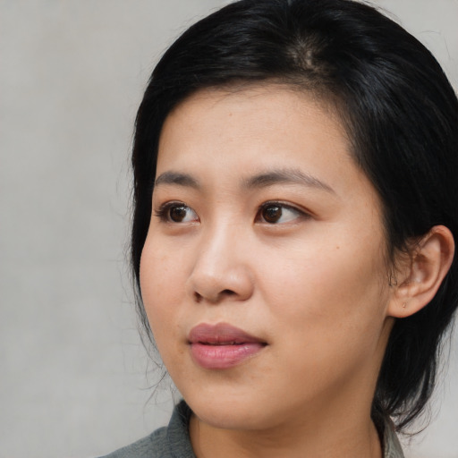 Joyful asian young-adult female with medium  black hair and brown eyes