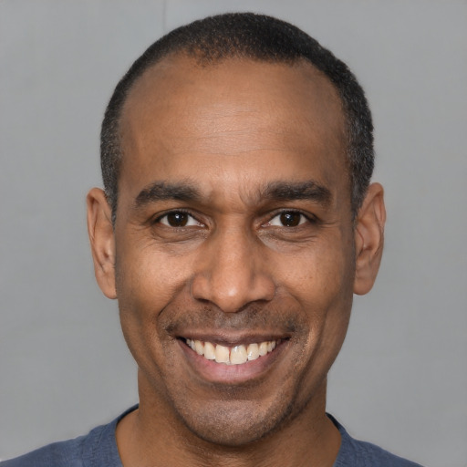 Joyful latino adult male with short  black hair and brown eyes