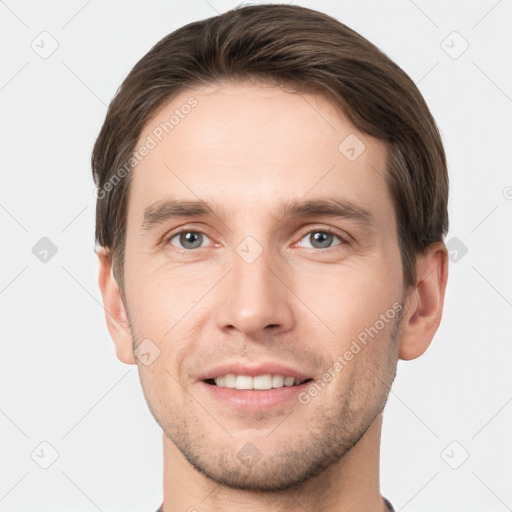 Joyful white young-adult male with short  brown hair and grey eyes