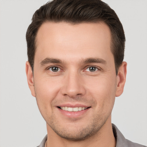 Joyful white young-adult male with short  brown hair and brown eyes