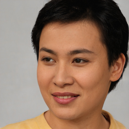 Joyful asian young-adult female with short  brown hair and brown eyes