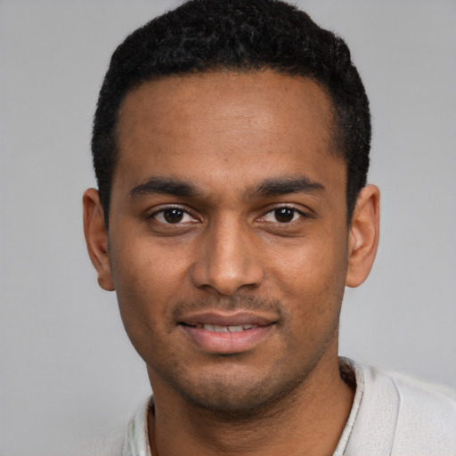 Joyful black young-adult male with short  black hair and brown eyes