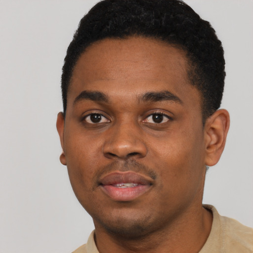 Joyful black young-adult male with short  black hair and brown eyes