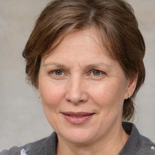 Joyful white adult female with medium  brown hair and blue eyes