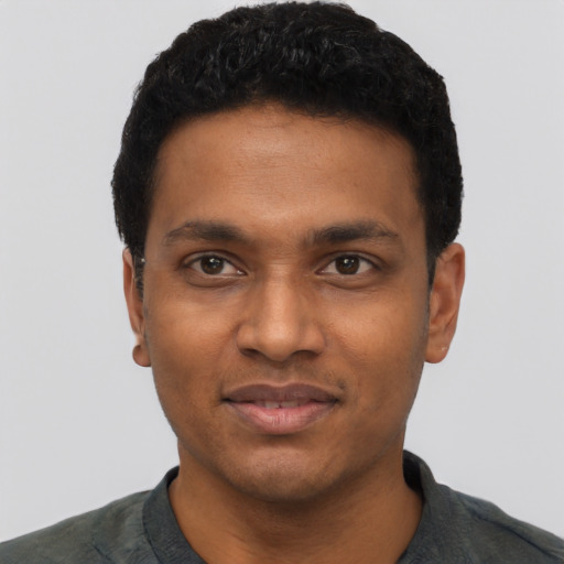 Joyful black young-adult male with short  black hair and brown eyes