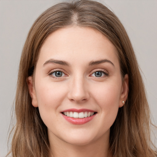 Joyful white young-adult female with long  brown hair and green eyes