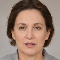 Joyful white adult female with medium  brown hair and grey eyes