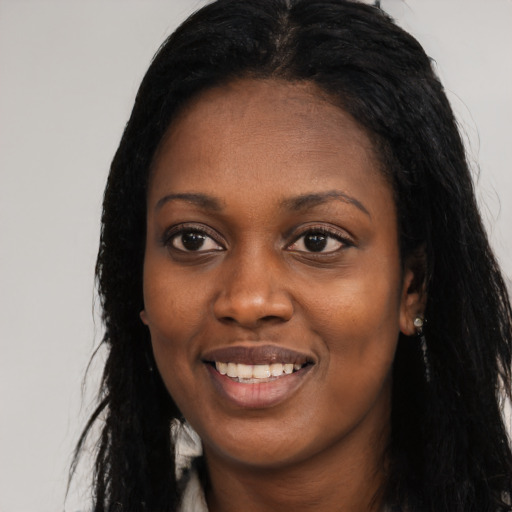 Joyful black young-adult female with long  black hair and brown eyes