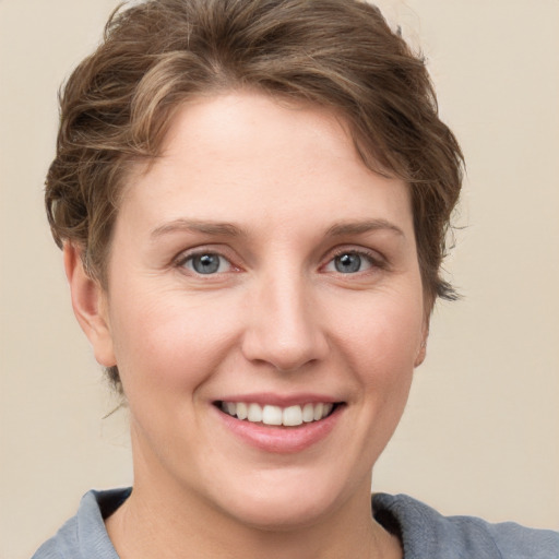 Joyful white young-adult female with short  brown hair and grey eyes