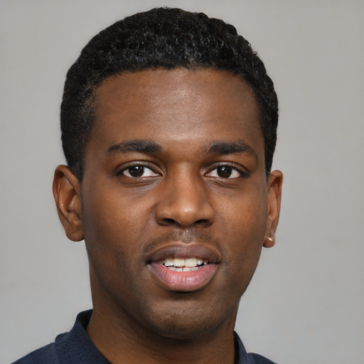 Joyful black young-adult male with short  black hair and brown eyes