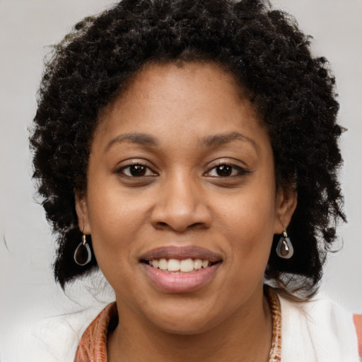 Joyful black young-adult female with long  brown hair and brown eyes