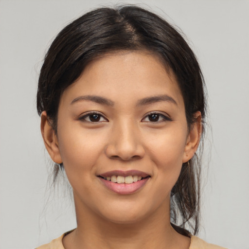 Joyful latino young-adult female with medium  brown hair and brown eyes