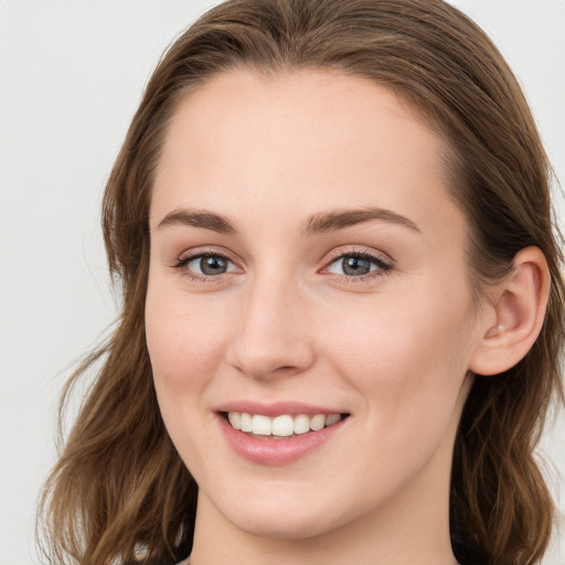 Joyful white young-adult female with long  brown hair and blue eyes