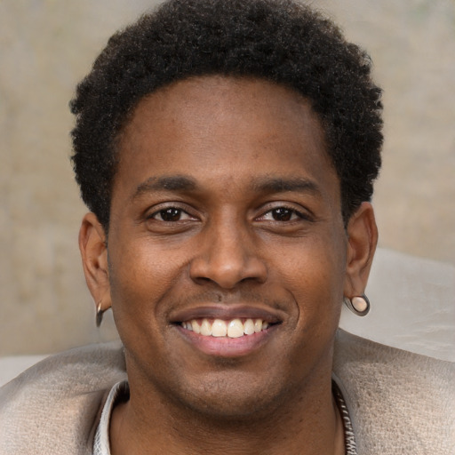 Joyful black young-adult male with short  brown hair and brown eyes