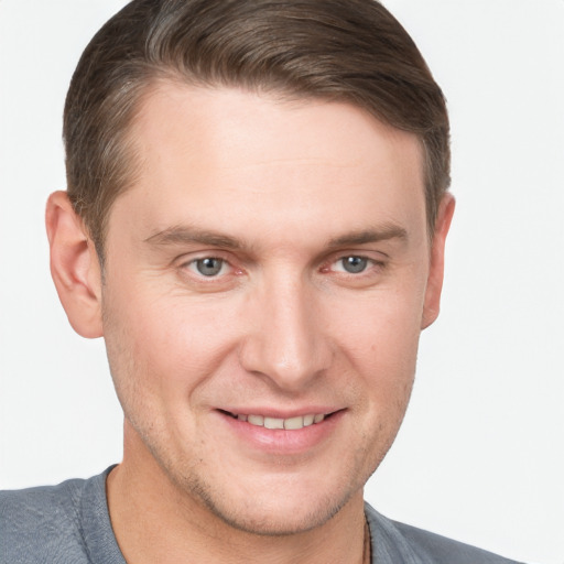 Joyful white young-adult male with short  brown hair and grey eyes