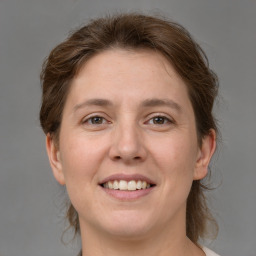 Joyful white adult female with medium  brown hair and grey eyes