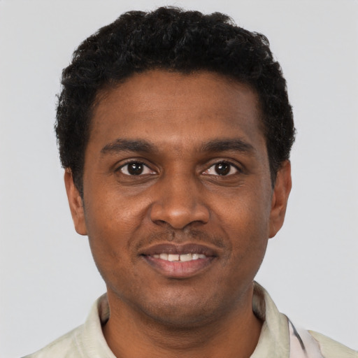 Joyful black young-adult male with short  black hair and brown eyes