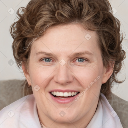 Joyful white adult female with medium  brown hair and blue eyes