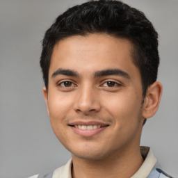 Joyful latino young-adult male with short  black hair and brown eyes