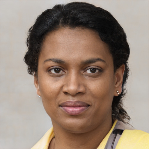 Joyful black young-adult female with short  brown hair and brown eyes