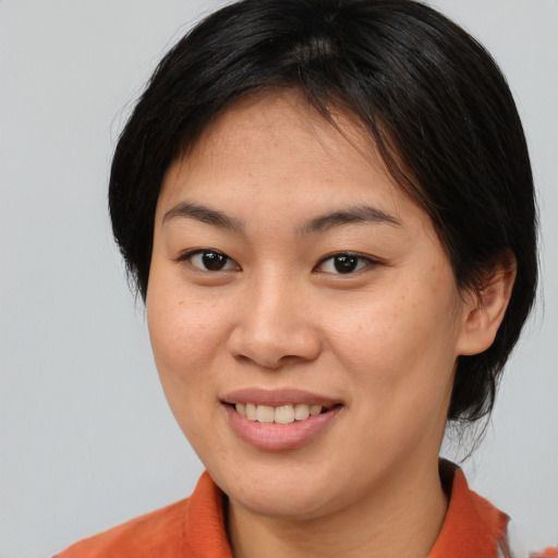 Joyful asian young-adult female with medium  brown hair and brown eyes