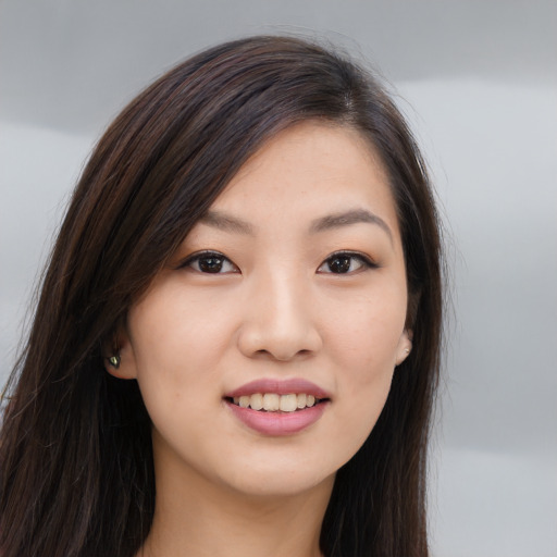 Joyful asian young-adult female with long  brown hair and brown eyes