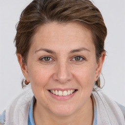 Joyful white adult female with medium  brown hair and grey eyes