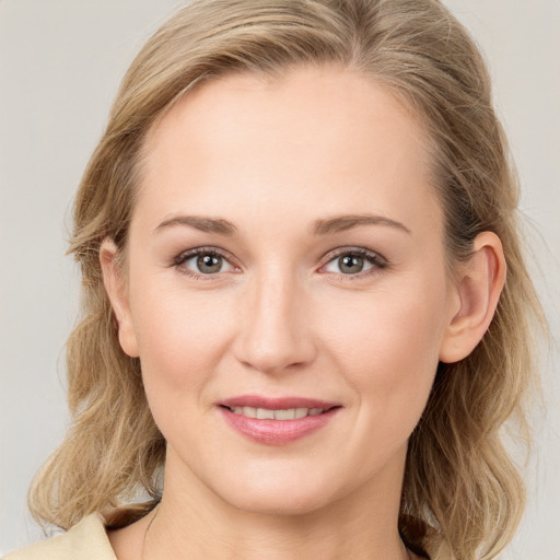 Joyful white young-adult female with medium  brown hair and blue eyes