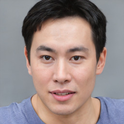 Joyful asian young-adult male with short  black hair and brown eyes