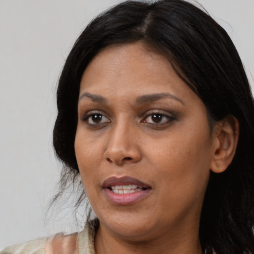 Joyful black adult female with long  black hair and brown eyes