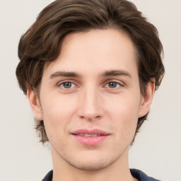 Joyful white young-adult male with medium  brown hair and grey eyes