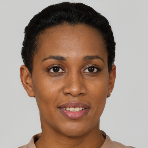 Joyful black young-adult female with short  black hair and brown eyes