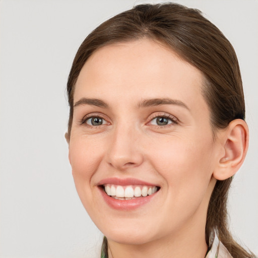 Joyful white young-adult female with medium  brown hair and grey eyes