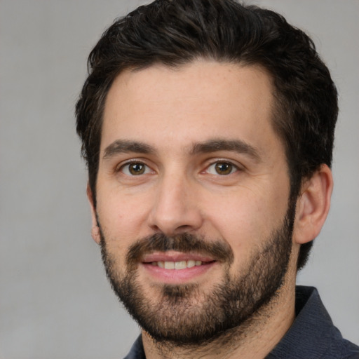 Joyful white adult male with short  black hair and brown eyes