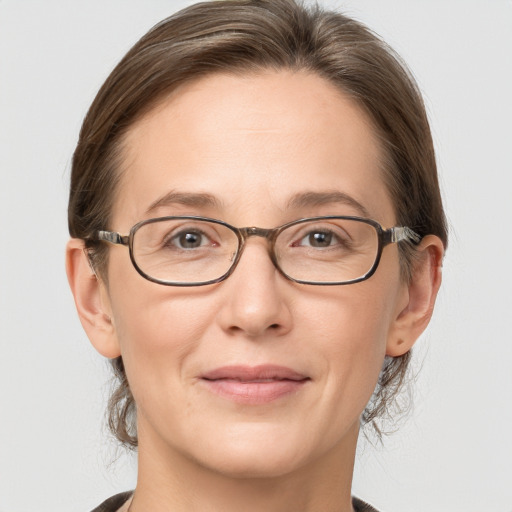 Joyful white adult female with medium  brown hair and grey eyes