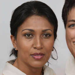 Joyful black adult female with medium  brown hair and brown eyes