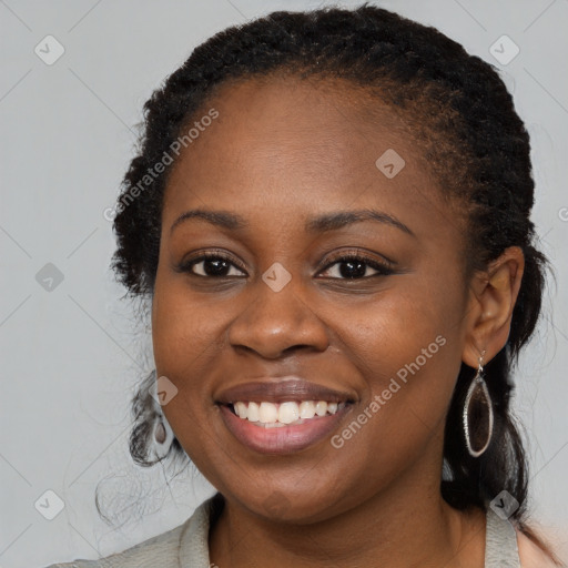 Joyful black young-adult female with long  brown hair and brown eyes