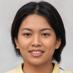 Joyful asian young-adult female with medium  brown hair and brown eyes