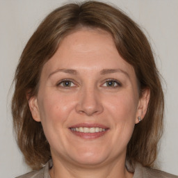 Joyful white adult female with medium  brown hair and grey eyes