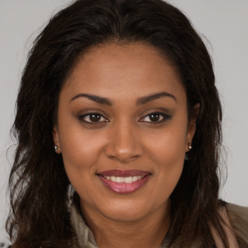 Joyful black young-adult female with long  brown hair and brown eyes