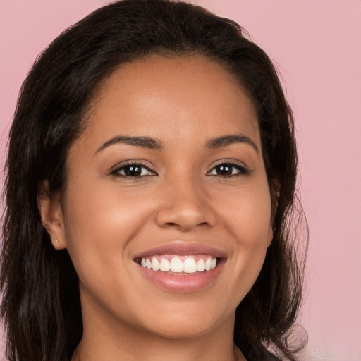 Joyful latino young-adult female with long  brown hair and brown eyes