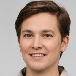 Joyful white young-adult male with short  brown hair and grey eyes