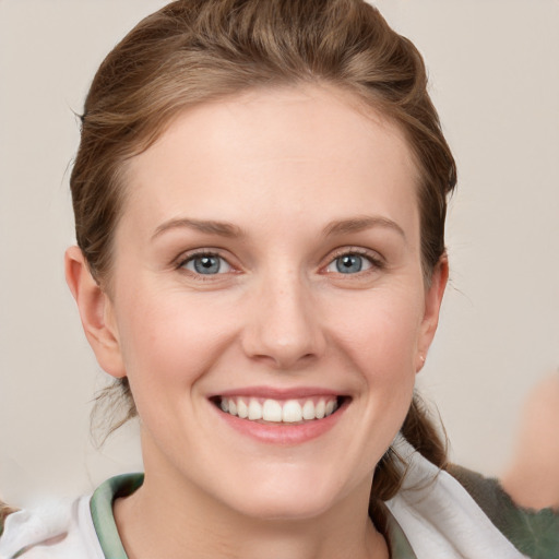 Joyful white young-adult female with short  brown hair and grey eyes