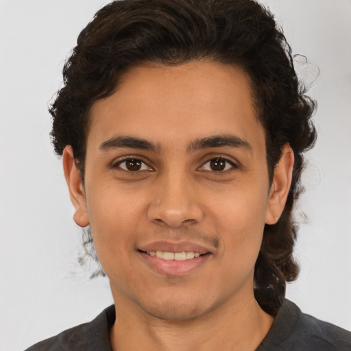 Joyful latino young-adult male with short  brown hair and brown eyes