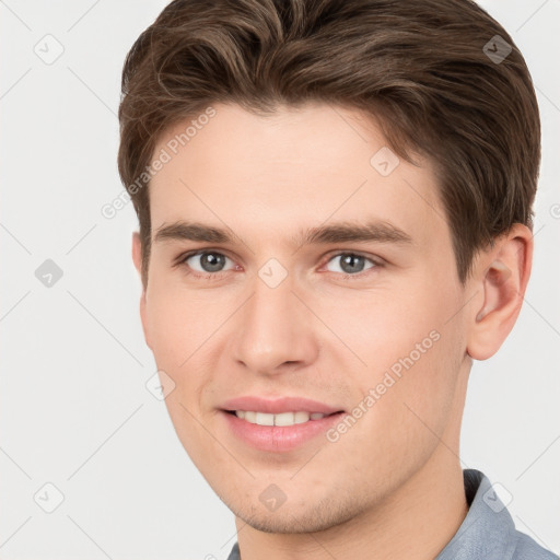 Joyful white young-adult male with short  brown hair and grey eyes