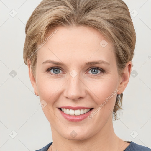 Joyful white young-adult female with medium  brown hair and grey eyes