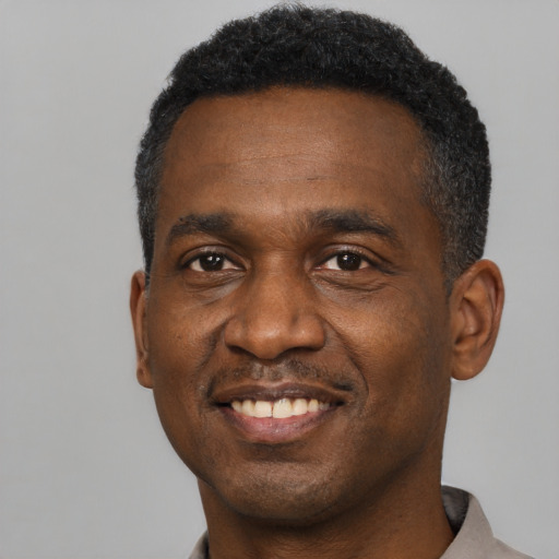 Joyful black adult male with short  black hair and brown eyes