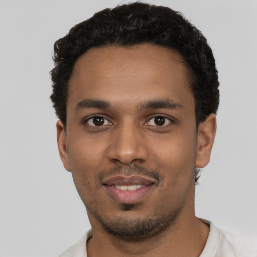 Joyful black young-adult male with short  black hair and brown eyes