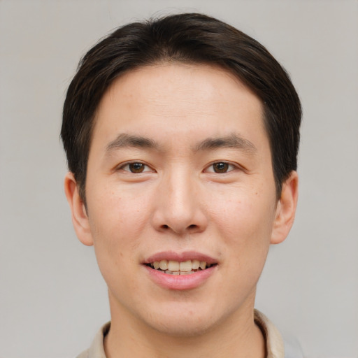 Joyful asian young-adult male with short  brown hair and brown eyes